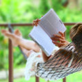 Young,Woman,Reading,A,Book,Lying,In,Hammock