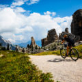 Woman,Cycling,In,Cortina,D&#8217;ampezzo,,Stunning,Cinque,Torri,And,Tofana