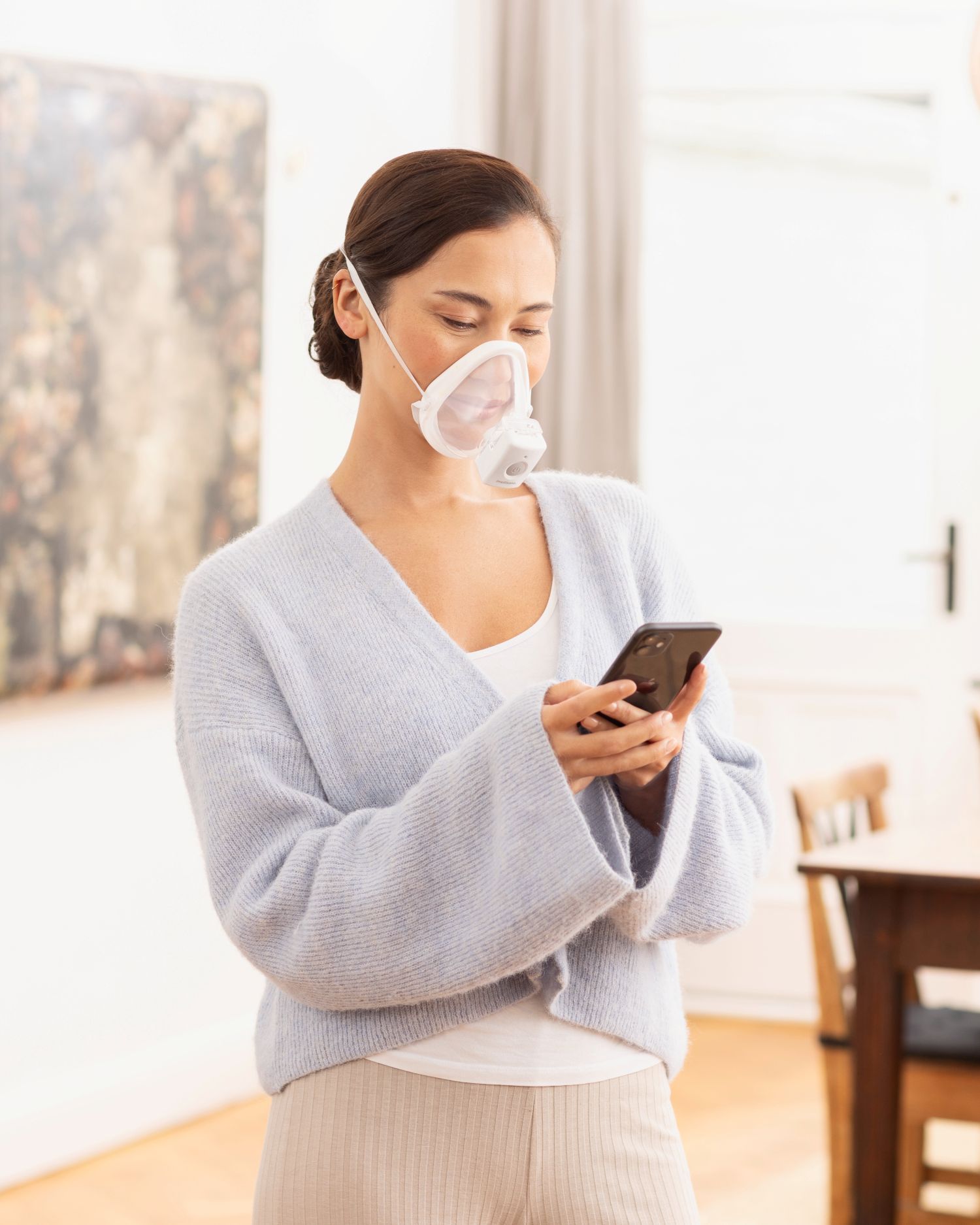 Woman uses the medisana IN 705 inhaler with mask comfortably on the sofa - effective inhalation therapy for respiratory diseases