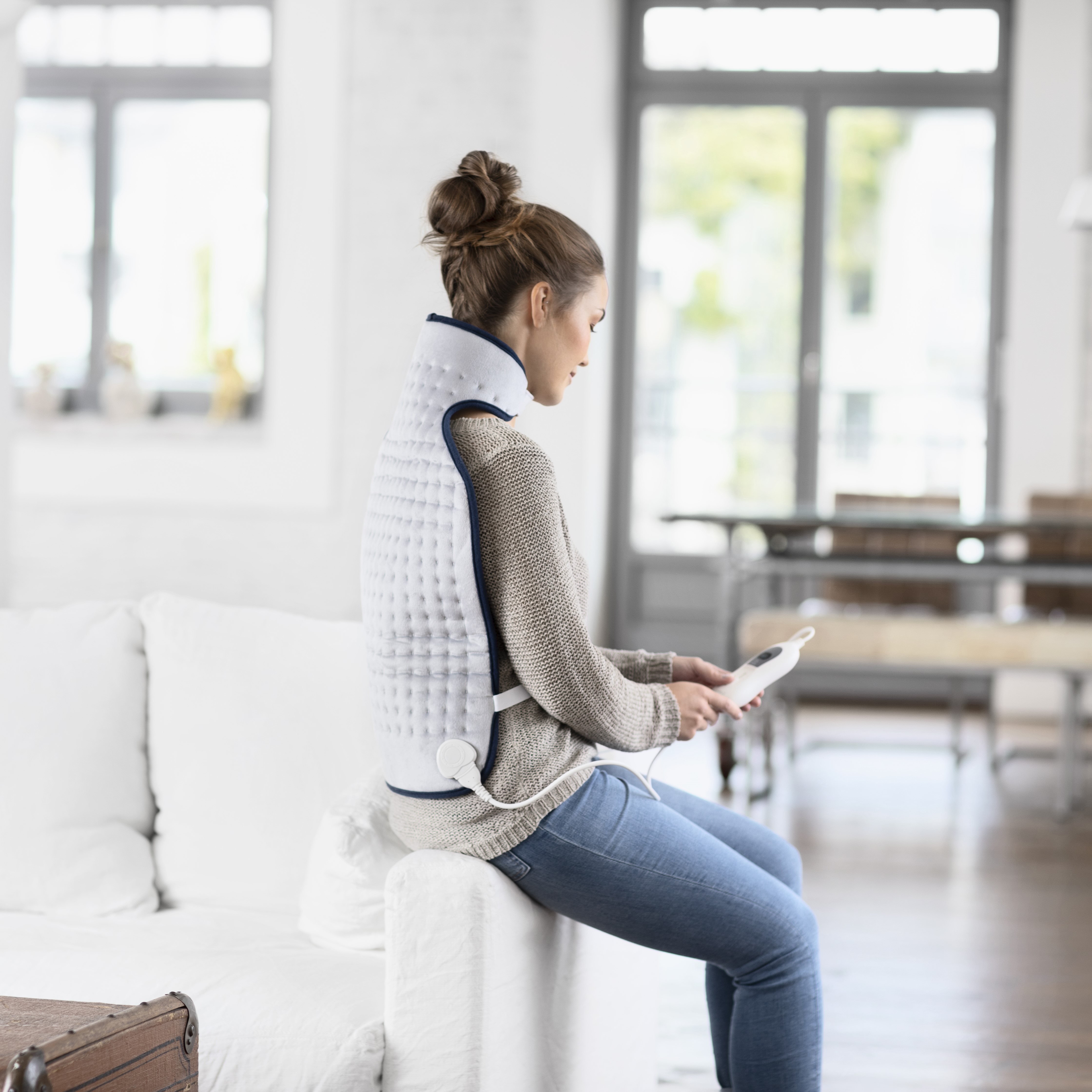 Die Nutzerin trägt den Nackenwärmer im Sitzen und genießt die wohltuende Wärme zur Entspannung von Nacken und Schultern.Nackenwärmer in Anwendung im SitzenNackenwärmer für gezielte Wärme und entspannten Komfor